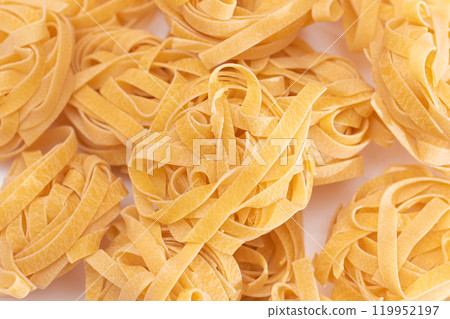 Scattered Classic Italian Raw Egg Fettuccine on White Table 119952197