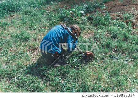 A man unloading an engine-powered lawnmower 119952334