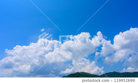 在夏日藍色的天空下，許多白雲在山頂上流動 119952699