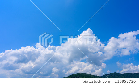 在夏日藍色的天空下，許多白雲在山頂上流動 119952720