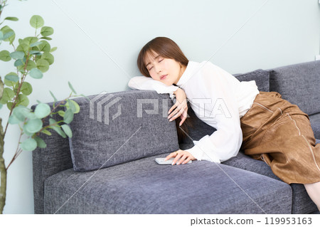 穿著休閒服的年輕女性睡著了，客廳，智慧型手機 119953163