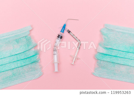 Broken Medical Syringe and Torn Medical Face Mask on the Pink Background 119953263