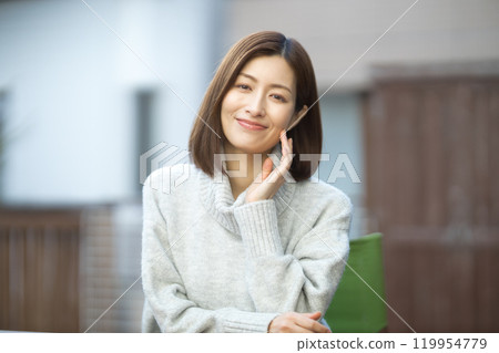 Beauty of a woman in her 40s wearing a sweater Beauty of a woman in her 40s wearing a sweater 119954779