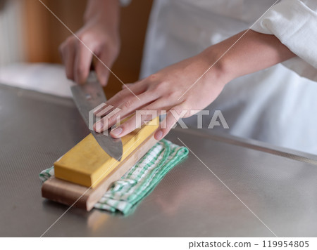 Chef sharpening a knife 119954805