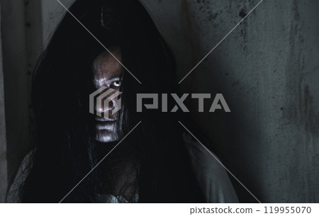 Scary ghost woman. Portrait of Asian ghost or zombie horror creepy scary have hair covering the face her eye at abandoned house dark tone, female make up zombie face, Happy Halloween day concept Scary ghost woman. Portrait of Asian ghost or zombie horror creepy scary have hair covering the face her eye at abandoned house dark tone, female make up zombie face, Happy Halloween day concept 119955070