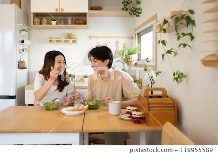Happy young couple enjoying a healthy meal together in a minimalist kitchen 119955589