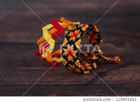 Tied woven friendship bracelets with bright colorful patterns handmade of thread isolated on white background 119955802