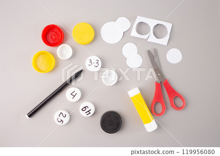 Step-by-step tutorial with scissors, glue, and markers on grey background. Educational concept for children learning and math activities, step in creative process, practice , 119956080