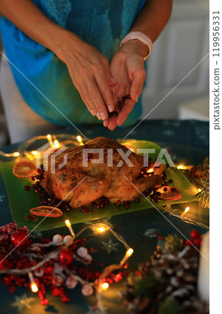 the moment of decorating a beautifully roasted turkey on a festive Christmas Eve table.The turkey, golden and succulent, serves as the centerpiece among an array of seasonal dishes and decorations. the moment of decorating a beautifully roasted turkey on a festive Christmas Eve table.The turkey, golden and succulent, serves as the centerpiece among an array of seasonal dishes and decorations. 119956331