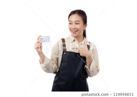 Portrait happiness young asian woman wearing apron holding and pointing credit card isolated. 119956651