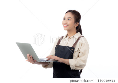 Portrait young asian business woman wearing apron holding laptop computer isolated. Portrait young asian business woman wearing apron holding laptop computer isolated. 119956653