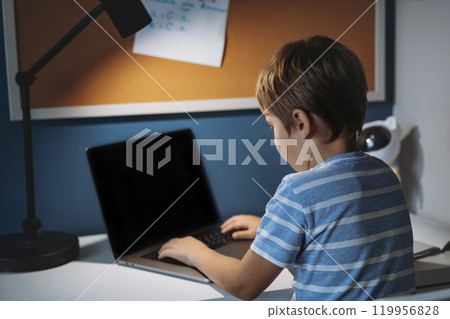 caucasian little boy studying at home typing on laptop caucasian little boy studying at home typing on laptop 119956828