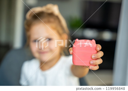 Little girl with a stamp with a name for signing children's things. Identification of personal clothing. Focus on stamp Little girl with a stamp with a name for signing children's things. Identification of personal clothing. Focus on stamp 119956848