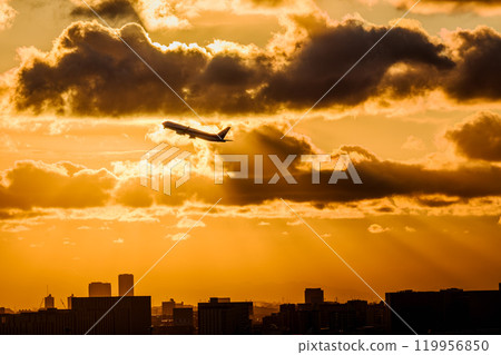 Passenger plane taking off at sunset 119956850