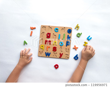 Colorful alphabet puzzle with childrens hands learning letters Colorful alphabet puzzle with childrens hands learning letters 119956971