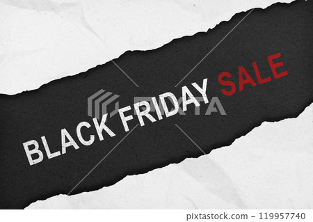 Top view of white rip paper and text of Black Friday on black background 119957740