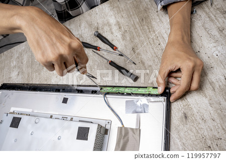 Man technician repairing television with a screwdriver Man technician repairing television with a screwdriver 119957797