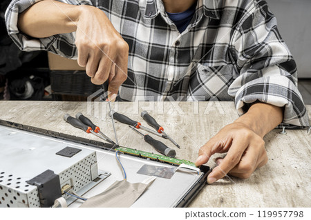 Man technician repairing television with a screwdriver Man technician repairing television with a screwdriver 119957798