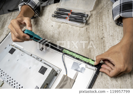 Man technician repairing television with a screwdriver 119957799