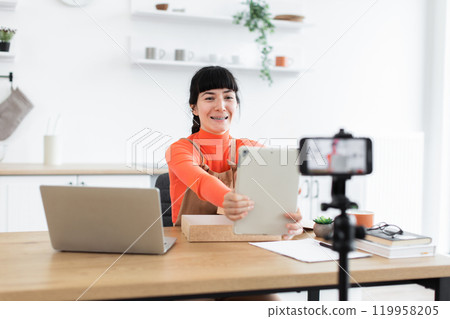 Caucasian female vlogger unboxing digital tablet for online audience Caucasian female vlogger unboxing digital tablet for online audience 119958205