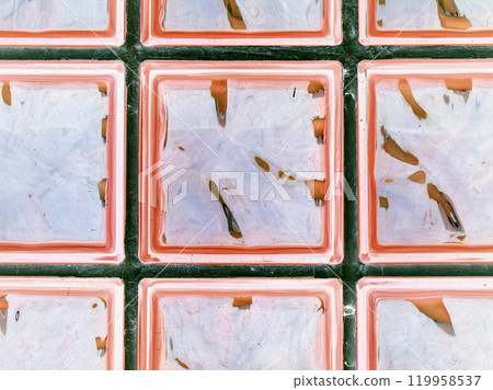 Transparent clear pink glass wall. Decorative block of brick and glass squares. Modern interior design for shower room. Abstract seamless background. 119958537