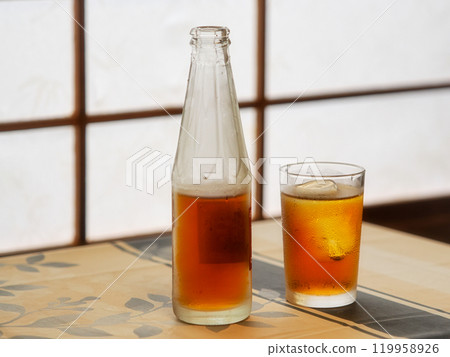 Chilled bottle of oolong tea and a cup on a table Chilled bottle of oolong tea and a cup on a table 119958926