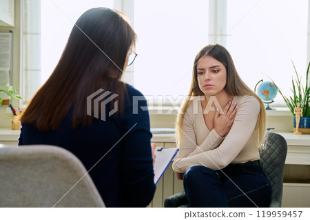 Sad unhappy young woman at therapy with female professional psychologist Sad unhappy young woman at therapy with female professional psychologist 119959457