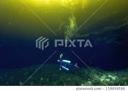 Diving in Mexican Cenote underwater cave with green gas cloud 119959586