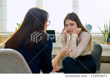 Sad unhappy young woman at therapy with female professional psychologist Sad unhappy young woman at therapy with female professional psychologist 119959671