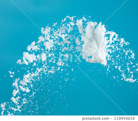 Snow dust element falling over blue sky. Fluffy White snow splash flying or throwing in mid air. Snowfall on blue background isolated 119959838