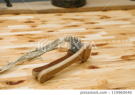 Traditional wooden rope hand tool on wooden surface for craft and repair Traditional wooden rope hand tool on wooden surface for craft and repair 119960040
