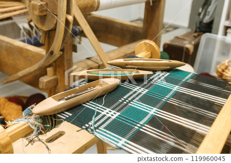Traditional loom weaving with wooden shuttles and colorful textile patterns Traditional loom weaving with wooden shuttles and colorful textile patterns 119960045