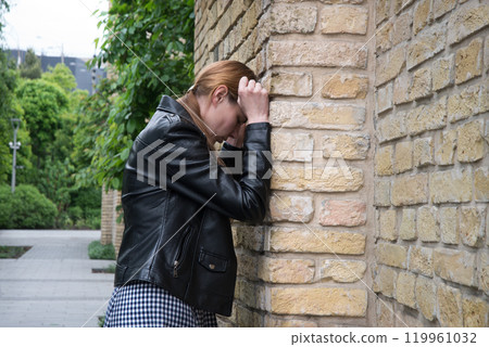 Sad woman at the wall 119961032