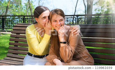 Two girls gossip in the park 119961039