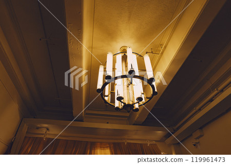 A room furnished with a simple antique chandelier 119961473