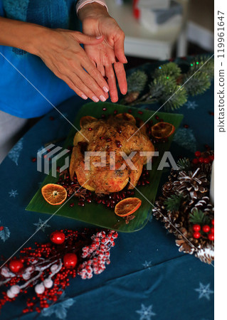 the moment of decorating a beautifully roasted turkey on a festive Christmas Eve table.The turkey, golden and succulent, serves as the centerpiece among an array of seasonal dishes and decorations. the moment of decorating a beautifully roasted turkey on a festive Christmas Eve table.The turkey, golden and succulent, serves as the centerpiece among an array of seasonal dishes and decorations. 119961647