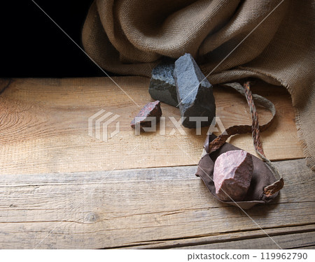 An antique leather sling lies on wooden desk 119962790