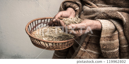 Farmer holds a sieve in his hands and sifts grain Farmer holds a sieve in his hands and sifts grain 119962802