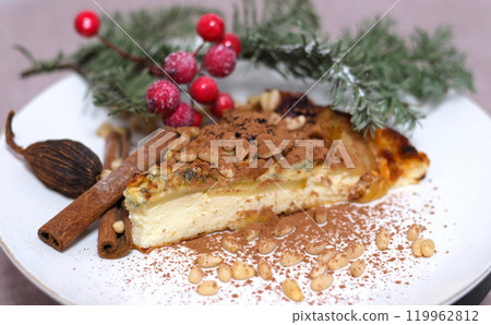 cinnamon on the pie Holiday food Christmas Stollen (Christstollen in Germany) over wooden plate with powdered sugar or icing sugar, pinecone, cinnamon, snowflake, Christmas tree. 119962812