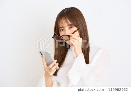 Young woman pushing her glasses aside Young woman pushing her glasses aside 119962962