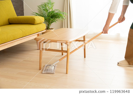 一位身穿綠色圍裙的高級女主婦/管家在客廳拖地板 119963648