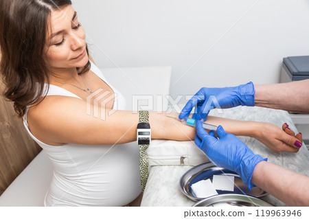 Nurse takes a blood sample from arm of pregnant woman Nurse takes a blood sample from arm of pregnant woman 119963946