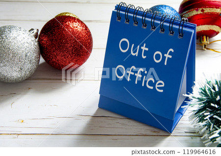 Out Of Office text on blue table notepad. Christmas celebration out of work concept. 119964616
