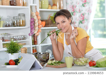 Portrait of a beautiful young woman cooking in the kitchen 119964653