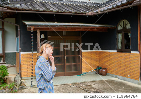 一個女人在古老的民居、空置的房子、遺產、鄉村前歪著頭 119964764