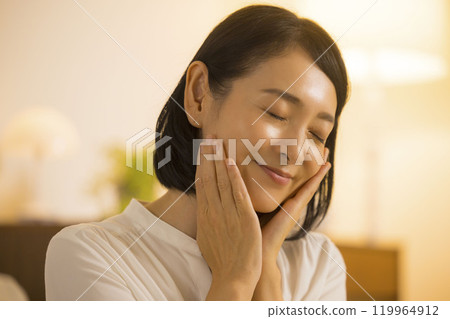 A middle-aged woman doing her skin care at night 119964912