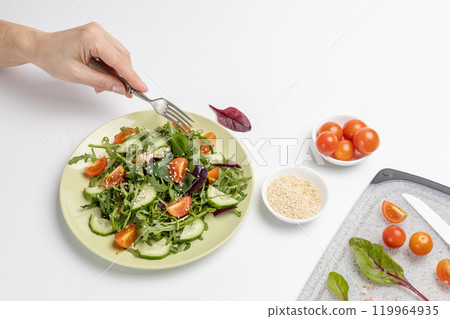 Vegetable salad of tomato, cucumber, greens on the plate with olive oil. Vegetable salad of tomato, cucumber, greens on the plate with olive oil. 119964935