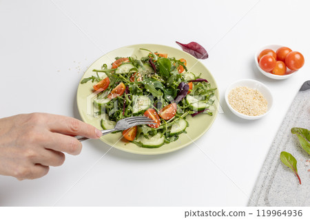 Vegetable salad of tomato, cucumber, greens on the plate with olive oil. Vegetable salad of tomato, cucumber, greens on the plate with olive oil. 119964936