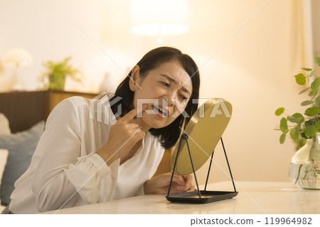 A middle-aged woman doing her skin care at night 119964982