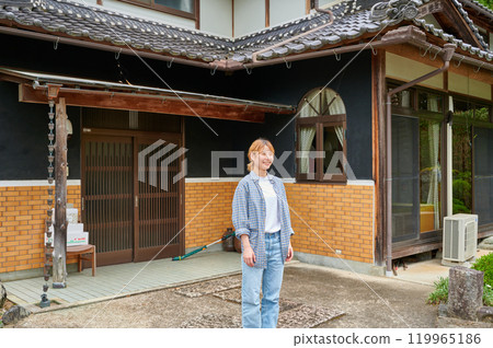 一個微笑的女人在一座古老的民宅、日本鄉村花園前 119965186